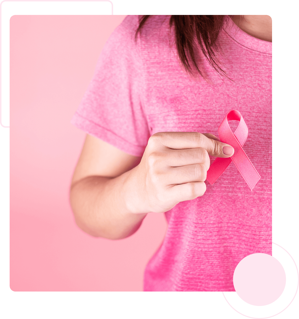 Hand holding a pink awareness ribbon.