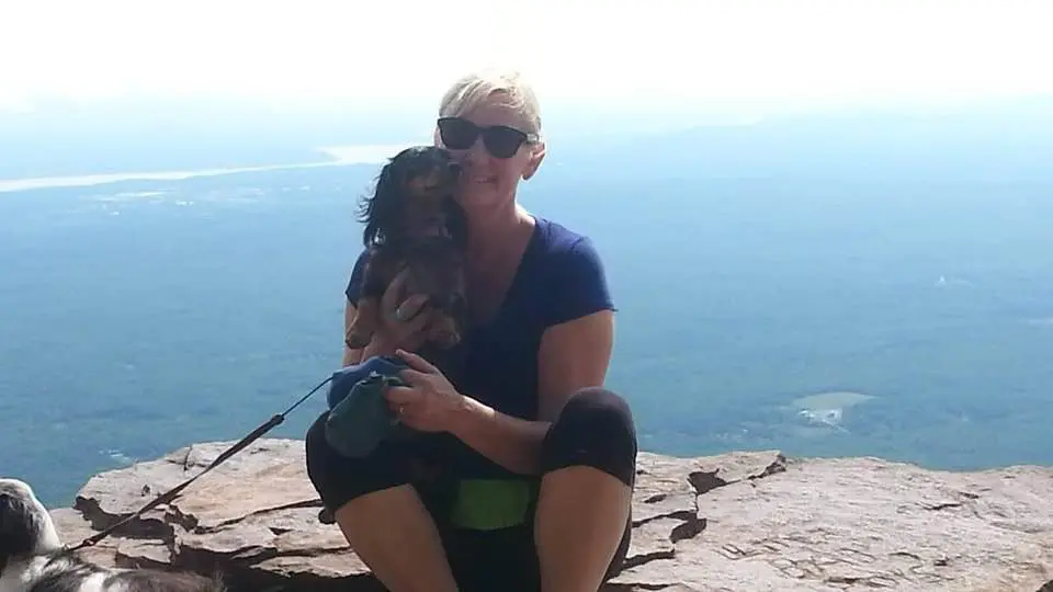 A woman hugging a child with a scenic ocean view in the background.
